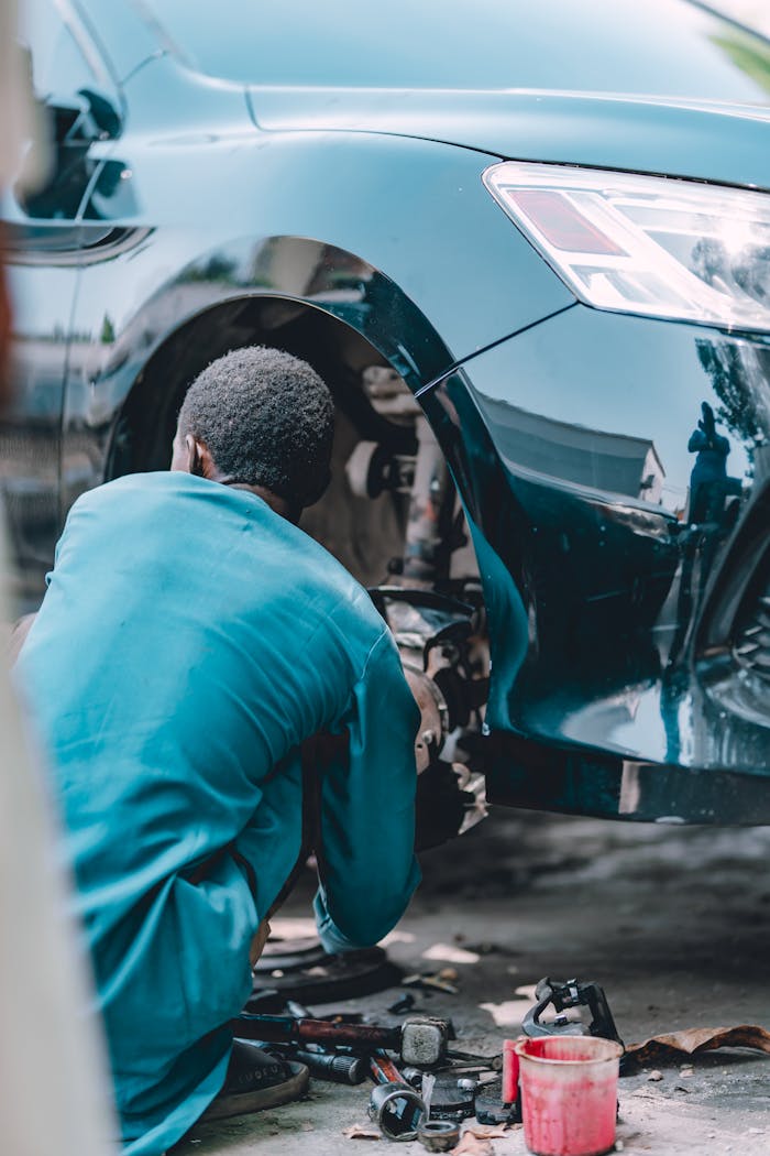 Crafting Captivating Headlines: Your awesome post title goes here An adult male mechanic working on car brake repair at an auto garage.